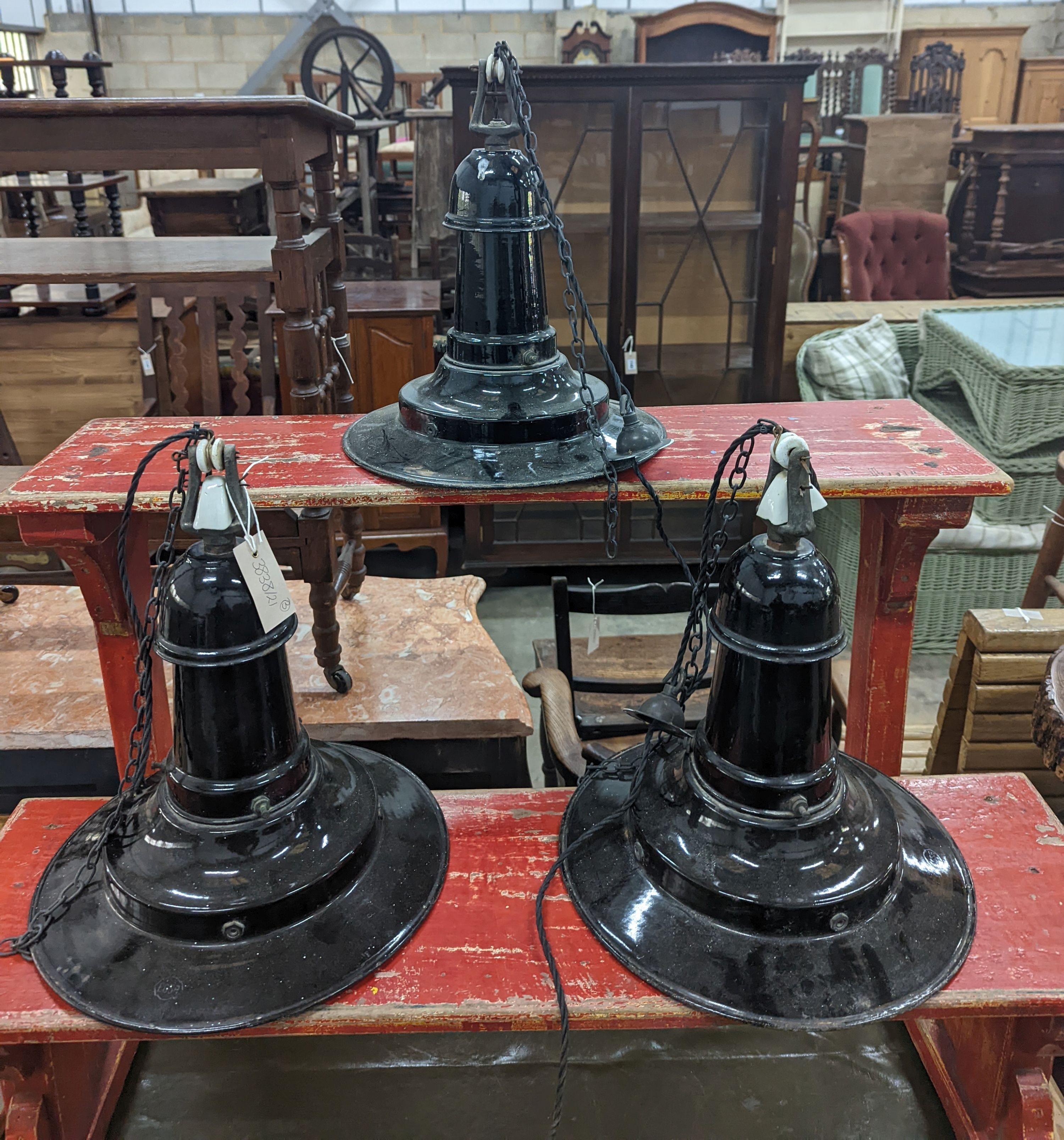 A set of three Continental black enamelled industrial style ceiling shades, height including fittings 39cm